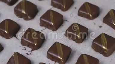 美丽美味的巧克力手工糖果与金色条纹面包纸。 特写镜头。